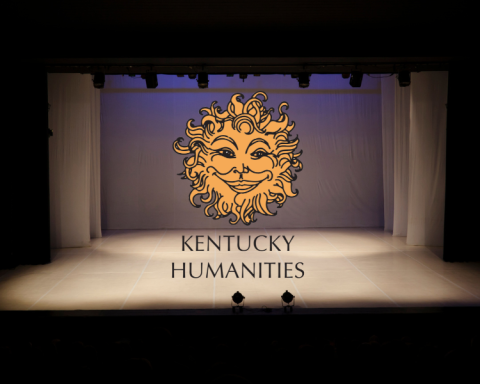 an empty brightly lit stage in a dark theatre and the logo and name of Kentucky Humanities in the center of the image.